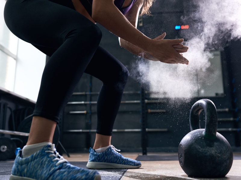 young-woman-lifting-kettlebells-in-crossfit-gym-min.jpg